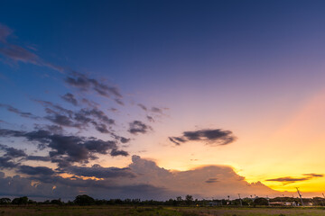 Twilight blue bright and orange yellow dramatic sunset sky in countryside or beach colorful cloudscape texture with white clouds air background.