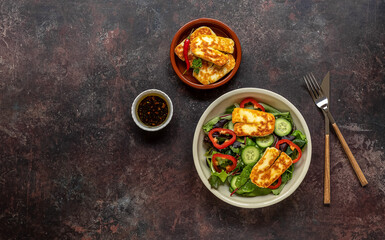 Green vegetarian salad from green leaves mix, vegetables, and halloumi cheese. Healthy recipe. Top view, copy space. 