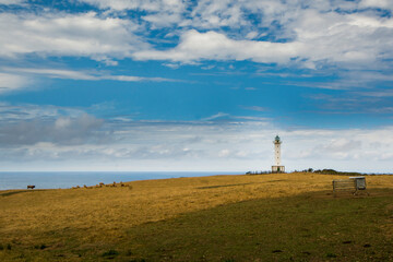Fototapeta na wymiar Typical white lighthouse in a landscape in the north of Spain, in Lastres Asturias,