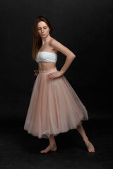 Young girl in white top and peach skirt dancing