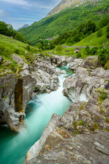 Long exposure of flowing water in Verzasca River at Lavertezzo - clear and turquoise water stream and rocks in Ticino - Valle Verzasca - Valley in Tessin - Travel destination in Switzerland