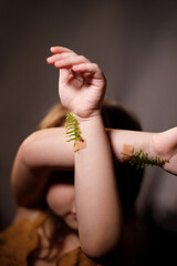 Ecology and against vaccination concept, close-up of hands of a child with fern sprigs pasted with plasters on arms