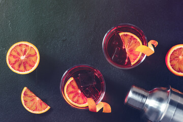 Orange cocktails, toned atmospheric image, with blood oranges and a shaker, overhead shot with copyspace - Powered by Adobe