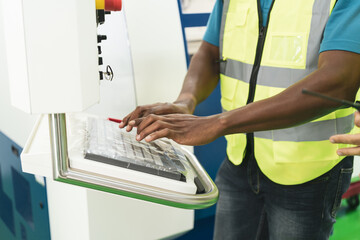 Close up hand of African worker typing on keyboard of machine control panel with copy space