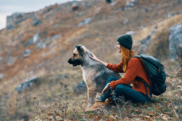 cheerful woman tourist next to a dog friendship mountains landscape