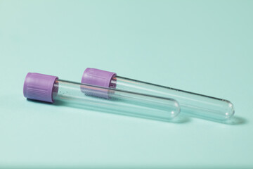 Purple empty vacuum blood collection tube test with EDTA as anticoagulant for Medical laboratory on turquoise background.