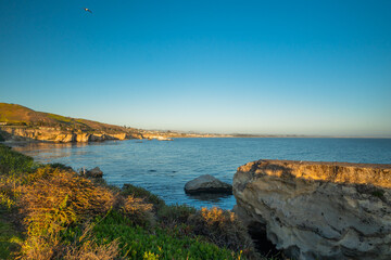 Scenic seascape, rocky cliffs and ocean view at sunset, clear blue sky background, California