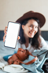 woman holding phone with white screen and bank credit card