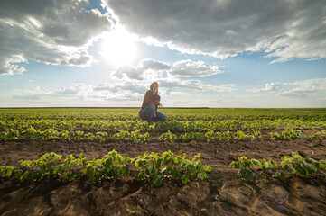 A young female farmer in a soybean field