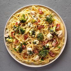 Homemade Chicken Bacon Broccoli Alfredo on a plate on a gray background, top view. Flat lay, overhead, from above.