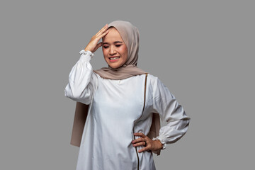 Young indonesian woman in hijab holding head with dizzy expression, stress, headache