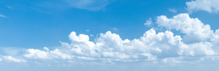 Naklejka na ściany i meble Panoramic photo of a blue sky with cumulus clouds.