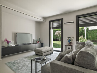 modern living room interior in the foreground a fabric sofa on the background there is a tv on the furniture