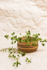 Thyme sprigs in wooden bowl.