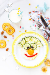 Fun Food for kids - smiling clown face made of a fried egg with cucumbers and bell pepper for a healthy breakfast for children