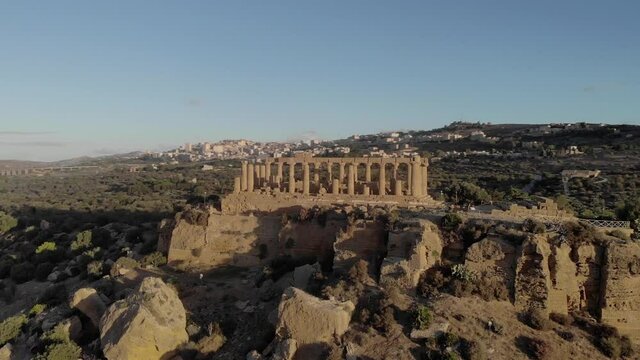 Golden morning aerial orbits around columns of ruined Temple of Juno