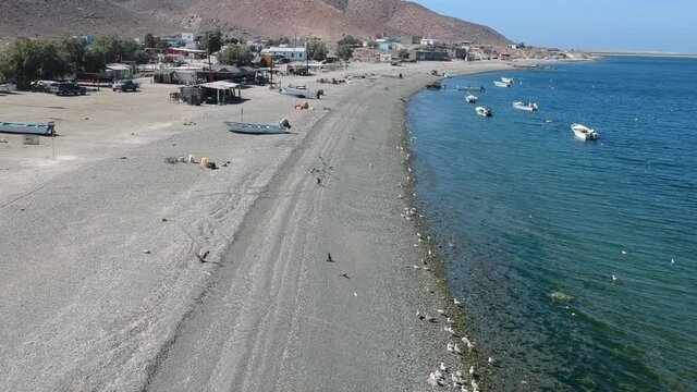 Drone video flying over a pebble beach on an island at Magdelena Bay Mexico while whale watching