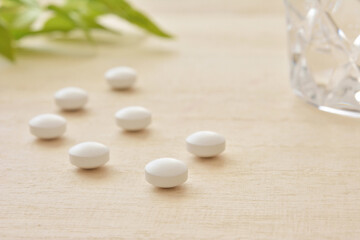 Fototapeta na wymiar White pills on a wooden table