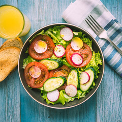 Vegetarian salad with bread and orange juice, healthy lunch, breakfast - fresh summer vegetable salad with tomatoes, cucumbers, radishes and lettuce, seasoned with olive oil.