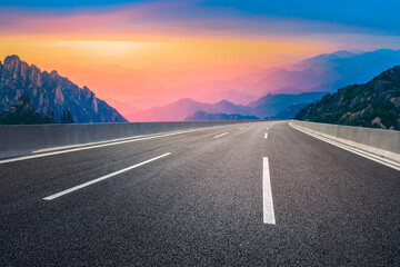 Asphalt highway and mountain landscape at sunset,road pavement background.
