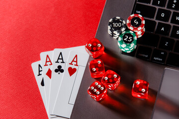 Online poker casino theme. Gambling chips and playing cards on a red background