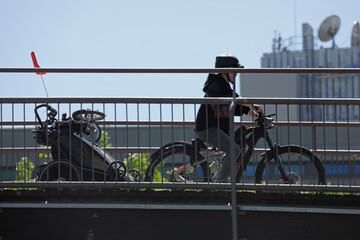 fahrradfahrer mit anhänger auf einer brücke in der stadt