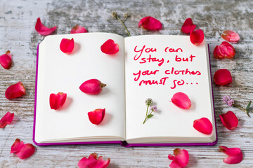A notebook with a sensual message and flower petals