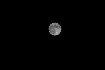 Full moon and craters taken with a telephoto lens. black and white photo.