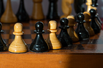 Wooden chess pieces on a chessboard. International Chess Day. Playing with a friend