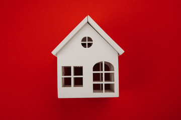White model of house isolated on red