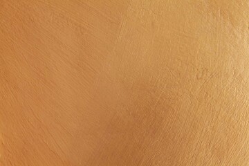 Smooth cement wall inside the building painted in bright gold texture and background seamless