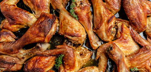 Hot chicken wings and legs on baking tray, Baked oven chicken. Long banner format, top view
