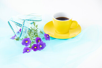 Obraz na płótnie Canvas 青いリボンと紫のペチュニアの花束とコーヒー