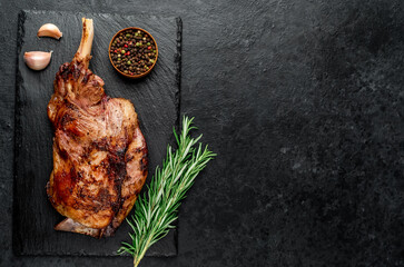 Baked lamb, sheep leg with rosemary. Stone background with copy space for your text
