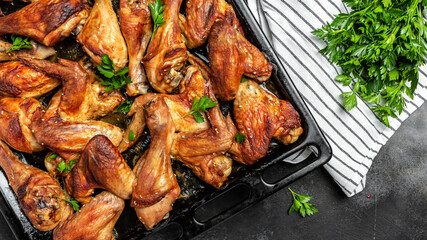Chicken legs, wings grilled, fried on oven on baking tray. Oven baked chicken pieces. Restaurant...