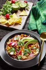 Mexican chicken and tortilla soup on a black plate