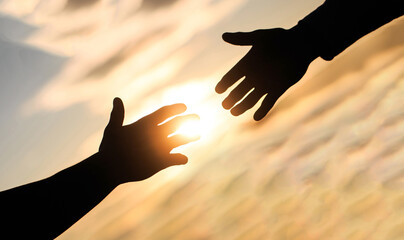 Giving a helping hand. Rescue, helping gesture or hands. Mercy, two hands silhouette on sky...