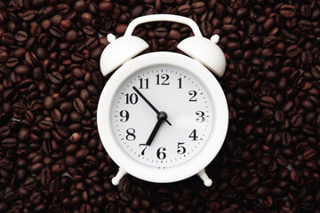 Alarm clock on coffee bean background