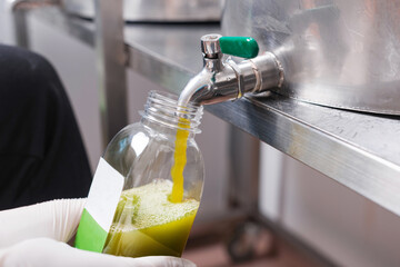 Close up photo of pouring fresh juice in bottle, JUICE INDUSTRY CONCEPT