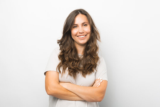 Portrait of young woman with crossed arms smiling and looking at camera