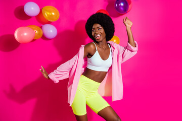 Photo of charming funky dark skin woman dressed crop top dancing balloons looking empty space isolated pink color background