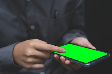 Close-up image of male hands using smartphone, Mobile phone green screen background, point finger on screen mobile phone closeup, person texting text message, businessman using mobile smart phone.