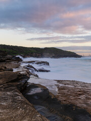 Fototapeta na wymiar Sunrise view by the ocean with rocky platform.