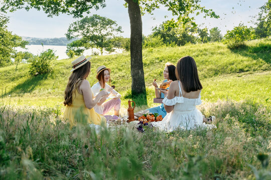 Summer Party Ideas. Safe and Festive Ways to Host Small, Outdoor Gathering with friends. People safely get together. Young women girl friends talking, laughing, having fun together at picnic