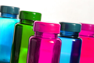 colorful bottles with pills over white background