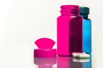 colorful bottles with pills over white background