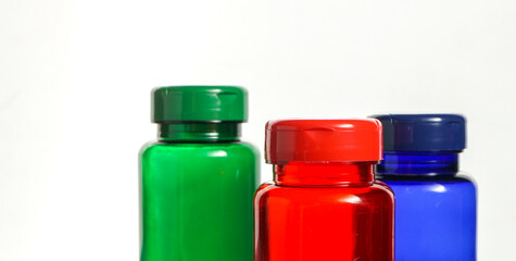 colorful bottles with pills over white background