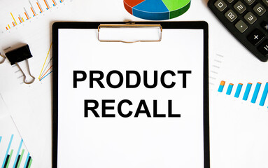 In the notebook text Product Recall, next to paper clips, glasses, pen, paper clips.