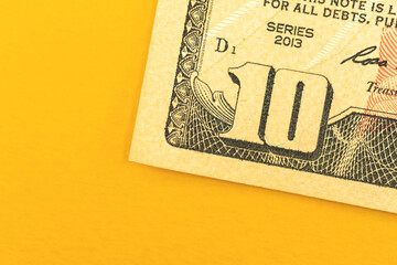 Deposit of small amount of money, ten dollar bill close-up on a yellow background, top view photo