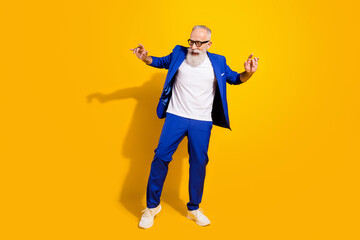 Full body photo of cheerful positive old gentleman dance good mood enjoy isolated on yellow color background